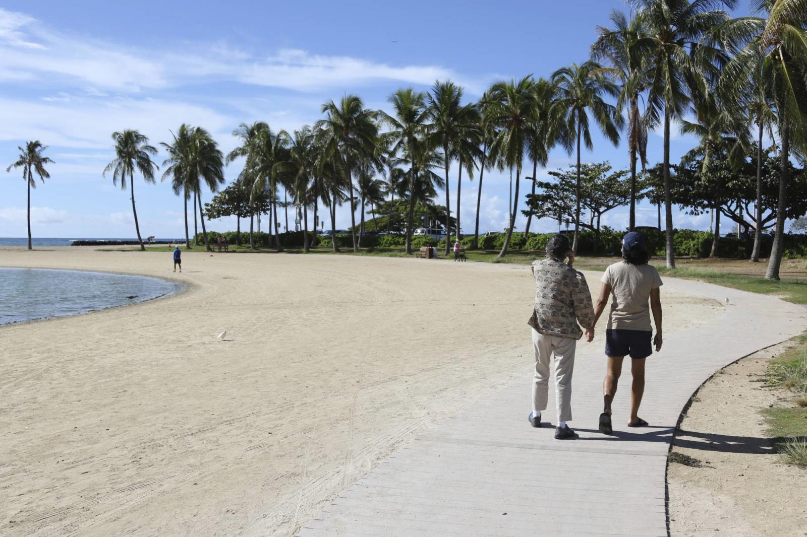 Two women walk on a near-empty Waikiki Beach in Ho<em></em>nolulu on Oct. 2. | AP