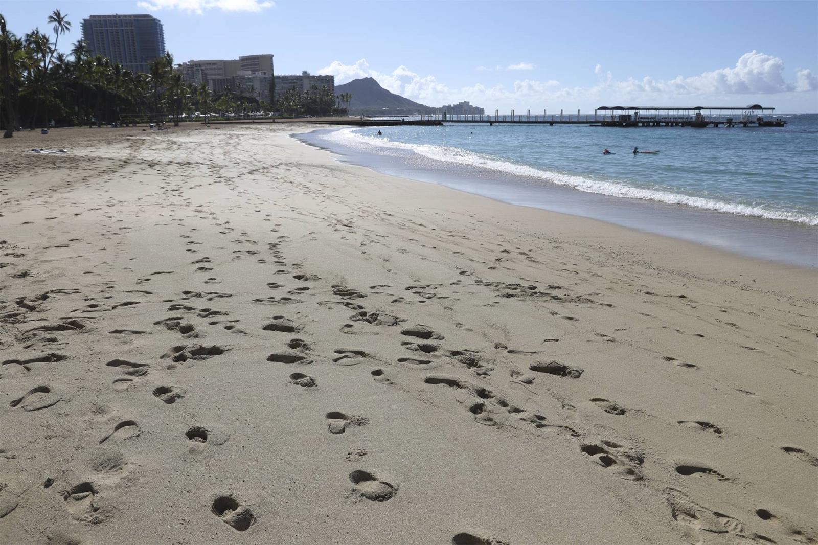 A near-empty Waikiki Beach is viewed on Thursday in Honolulu. A new travel testing program allows visitors from Japan who test negative for COVID-19 to come to Hawaii and avoid two weeks of mandatory quarantine. | AP