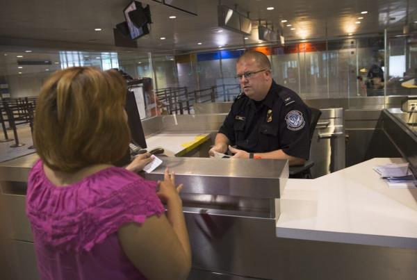 CBP officer inspects travel docu<em></em>ments for noncitizen